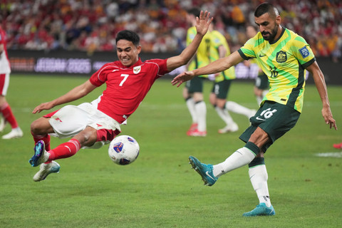 Pemain Timnas Indonesia Marselino Ferdinan berebut bola dengan pemain Timnas Australia Aziz Behich pada pertandingan Ronde 3 Kualifikasi Piala Dunia 2026 di Sydney Stadium,Sydney, Australia, Kamis (20/3/2025). Foto: Mark Baker/AP Photo
