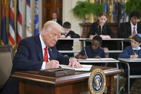 Presiden AS Donald Trump melakukan tanda tangan perintah esekutif di Gedung Putih, Washington DC, Amerika Serikat, Kamis (20/3/2025). Foto: Mandel Ngan/AFP
