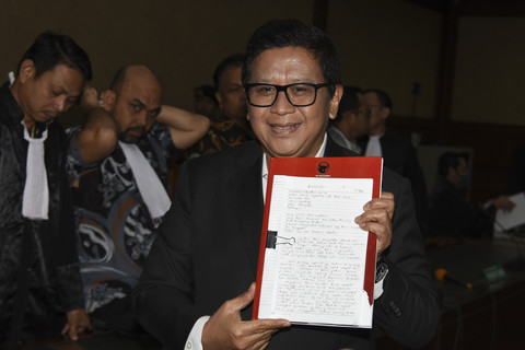 Sekjen DPP PDI Perjuangan Hasto Kristiyanto (tengah) menunjukkan berkas nota keberatannya saat skors sidang pembacaan eksepsi di Pengadilan Tipikor, Jakara Pusat, Jumat (21/3/2025). Foto: Indrianto Eko Suwarso/ANTARA FOTO