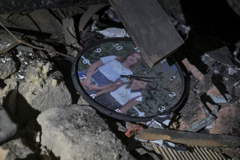Sebuah jam dinding dengan foto warga Ukraina terlihat dibagunan yang hancur akibat serangan pesawat tak berawak Rusia saat konflik Rusia dan Ukraina di Zaporizhzhia, Ukraina, Jumat (21/3/2025). Foto: Stringer/Reuters