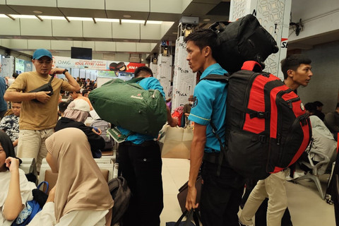 Porter membawakan barang milik penumpang di Stasiun Senen, Jakarta, Minggu (23/3/2025). Foto: Luthfi Humam/kumparan
