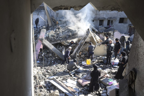 Warga Palestina memeriksa puing-puing dan reruntuhan di lokasi serangan Israel pada malam sebelumnya di kamp pengungsi Nuseirat di Jalur Gaza tengah, Minggu (23/3/2025). Foto: EYAD BABA/AFP