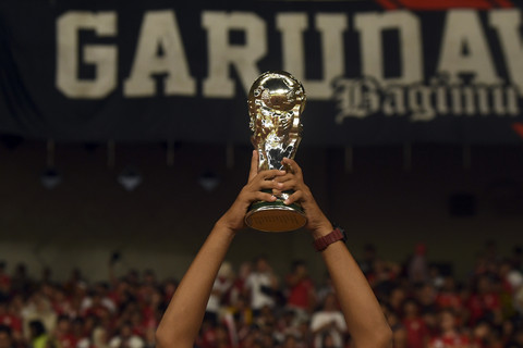 Pendukung Timnas Indonesia mengangkat trofi seusai Indonesia mengalahkan Timnas Bahrain dalam pertandingan Grup C putaran ketiga Kualifikasi Piala Dunia 2026 zona Asia di Stadion Utama Gelora Bung Karno, Senayan, Jakarta, Selasa (25/3/2025). Foto: Muhammad Adimaja/ANTARA FOTO