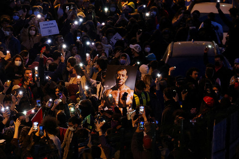 Seseorang membawa gambar Wali Kota Istanbul Ekrem Imamoglu saat orang-orang menyalakan lampu ponsel selama protes terhadap penangkapan Imamoglu sebagai bagian dari penyelidikan korupsi, di Istanbul, Turki, 25 Maret 2025. Foto: REUTERS/Umit Bektas