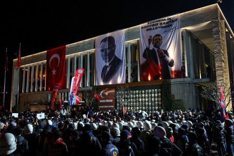 Petugas polisi berjaga-jaga saat orang-orang ikut serta dalam protes terhadap penangkapan Wali Kota Istanbul Ekrem Imamoglu sebagai bagian dari penyelidikan korupsi, di depan gedung Pemerintah Kota Metropolitan Istanbul, di Istanbul, Turki, (26/3). Foto: REUTERS/Murad Sezer