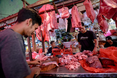 Pedagang memotong daging sapi di Pasar Minggu pada Kamis (27/3). Foto: Jamal Ramadhan/kumparan