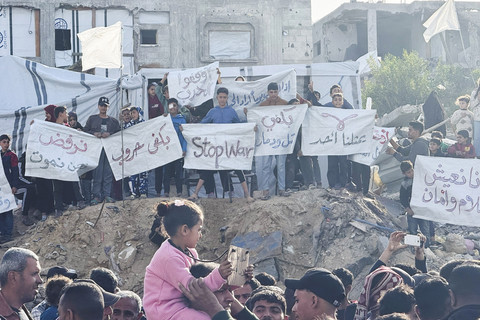 Sejumlah warga Palestina membentangkan poster saat berunjuk rasa di Beit Lahiya, Jalur Gaza Utara, Selasa (25/3/2025). Foto: Stringer/Reuters