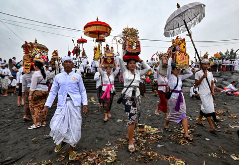 Umat Hindu berdoa selama upacara Melasti di pantai di daerah Denpasar, Rabu (27/3). Foto: Sonny Tumbelaka / AFP