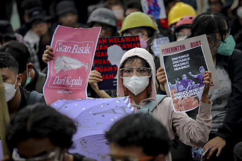 Seorang demonstran membentangkan poster saat unjuk rasa menolak RUU TNI di depan kompleks Parlemen, Senayan, Jakarta, Kamis (27/3/2025). Foto: Jamal Ramadhan/kumparan