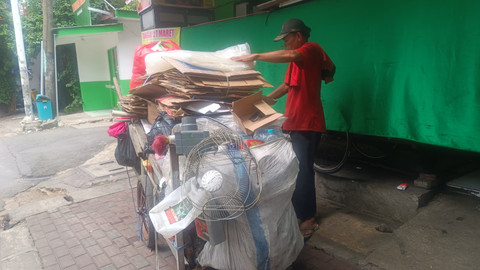 Jack (52) mengumpulkan barang bekas di kawasan Mampang, Jaksel, Jumat (28/3).  Foto: Thomas Bosco/kumparan