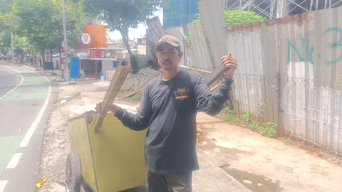 Jumadi (42), tetap memulung jelang Lebaran di kawasan Mampang, Jaksel, Jumat (28/3). Foto: Thomas Bosco/kumparan