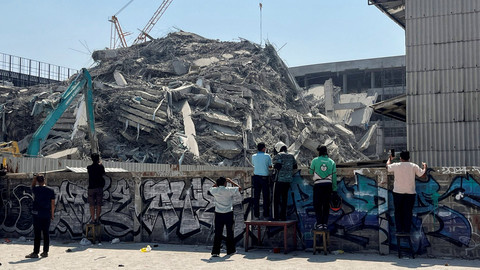 Warga melihat bangunan yang runtuh di Bangkok setelah gempa bumi dahsyat mengguncang Myanmar pada hari Jumat (28/3). Foto: REUTERS/Ann Wang