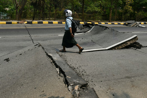 Warga berjala melewati jalan yang rusak akibat gempa di Naypyidaw, Myanmar, Jumat (28/3/2025). Foto: Sai Aung MAIN / AFP