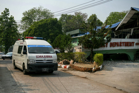 Sebuah ambulans melewati gedung unit gawat darurat (UGD) sebuah rumah sakit yang ambruk diguncang gempa di Naypyidaw, Myanmar, Jumat (28/3/2025). Foto: Sai Aung MAIN / AFP