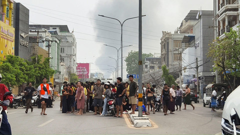 Warga berkumpul di dekat bangunan yang rusak terdampak gempa di Mandalay, Myanmar, Jumat (28/3/2025). Foto: Stringer/REUTERS