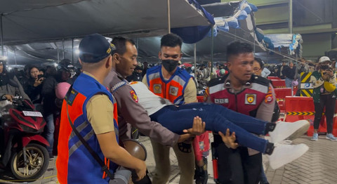Petugas kesehatan mengevakusi pemudik yang pingsan saat antrean di Pelabuhan Ciwandan, Kota Cilegon, Banten, Sabtu subuh (29/3/2025). Foto: Dok. kumparan