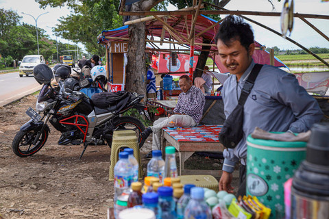 Pemudik beristirahat sambil menyantap hidangan yang ada di warung musiman pinggir jalan di kawasan Karawang, Jawa Barat, Sabtu (29/3/2025).    Foto: Iqbal Firdaus/kumparan