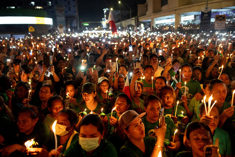 Para pendukung mantan Presiden Filipina Rodrigo Duterte memegang lilin dan telepon genggam yang menyala selama acara peringatan ulang tahun yang ke-80 Duterte di kota Davao City, Filipina, Jumat (28/3/2025). Foto: Eloisa Lopez/REUTERS
