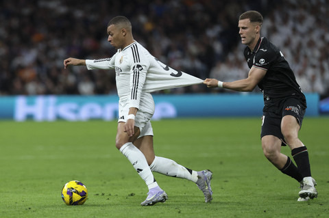 Pemain Real Madrid Kylian Mbappe berusaha melewati pemain CD Leganes Diego Garcia saat pertandingan Laliga Spanyol di Santiago Bernabeu, Madrid, Spanyol, Sabtu (29/3/2025). Foto: Thomas Coex/AFP