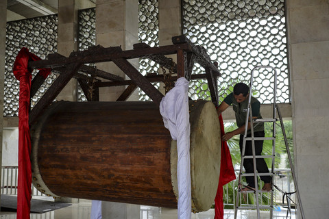 Pekerja menghias bedug menjelang pelaksaan Salat Idul Fitri di Masjid Istiqlal, Jakarta, Minggu (30/3/2025). Foto: Jamal Ramadhan/kumparan