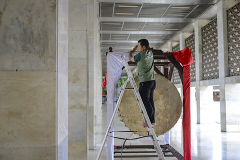 Pekerja menghias bedug menjelang pelaksaan Salat Idul Fitri di Masjid Istiqlal, Jakarta, Minggu (30/3/2025). Foto: Jamal Ramadhan/kumparan