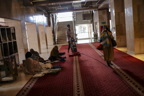 Pekerja membersihkan sajadah menggunakan alat vakum pembersih menjelang pelaksaan Salat Idul Fitri di Masjid Istiqlal, Jakarta, Minggu (30/3/2025). Foto: Jamal Ramadhan/kumparan