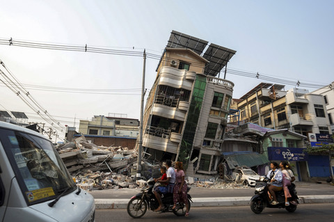 Para komuter melewati sebuah bangunan yang runtuh, setelah gempa bumi yang kuat, di Mandalay, Myanmar, Minggu (30/3/2025). Foto: Stringer/REUTERS