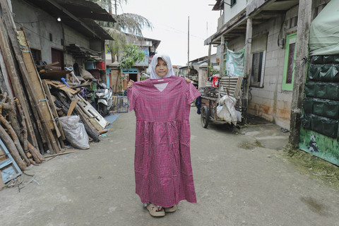 Penerima Baju: Anak penerima program kumparan 'Cerita Baru untuk Bajumu' menunjukkan baju yang diterimanya di Kampung Pemulung, Duren Sawit, Jakarta Timur. Foto: Jamal Ramadhan/kumparan