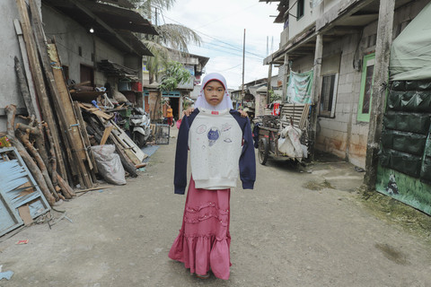 Penerima Baju: Anak penerima program kumparan 'Cerita Baru untuk Bajumu' menunjukkan baju yang diterimanya di Kampung Pemulung, Duren Sawit, Jakarta Timur. Foto: Jamal Ramadhan/kumparan