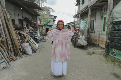 Penerima Baju: Anak penerima program kumparan 'Cerita Baru untuk Bajumu' menunjukkan baju yang diterimanya di Kampung Pemulung, Duren Sawit, Jakarta Timur. Foto: Jamal Ramadhan/kumparan