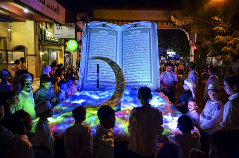 Anak-anak berada dekat replika Al Quran saat takbir keliling di kawasan kota tua Ampenan, Mataram, NTB, Minggu (30/3/2025). Foto: Ahmad Subaidi/ANTARA FOTO