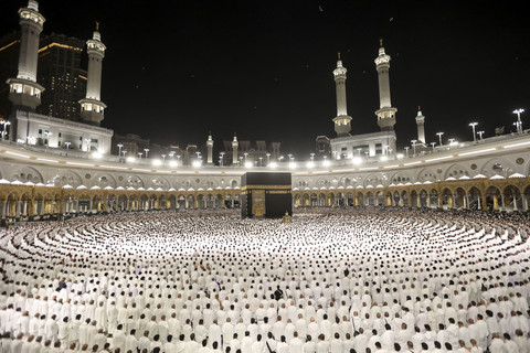Umat Muslim melaksanakan salat subuh di sekitar Ka'bah di Masjidil Haram di kota suci Mekkah, Arab Saudi, pada awal Idul Fitri, yang menandai berakhirnya bulan puasa Ramadan, Minggu (30/3/2025). Foto: Abdel Ghani Bashir/AFP