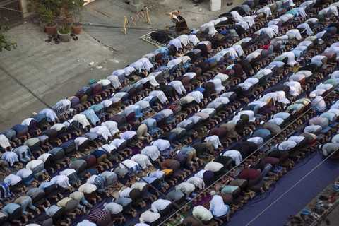 Umat Muslim melaksanakan salat subuh untuk memulai perayaan Idul Fitri, yang menandai berakhirnya bulan puasa Ramadan di sebuah jalan dekat masjid yang hancur di Mandalay, Myanmar, Senin (31/3/2025). Foto: Sai Aung Main/AFP