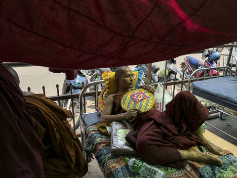Seorang biksu Buddha berbaring di tempat tidur di kompleks Rumah Sakit Umum Mandalay di Mandalay, Myanmar (31/3/2025). Foto: Sai Aung Main/AFP