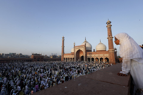 Seorang gadis Muslim memperhatikan orang-orang yang sedang melaksanakan salat di Jama Masjid pada perayaan Idul Fitri, di kawasan tua Delhi, India, Senin (31/3/2025). Foto: Priyanshu Singh/REUTERS