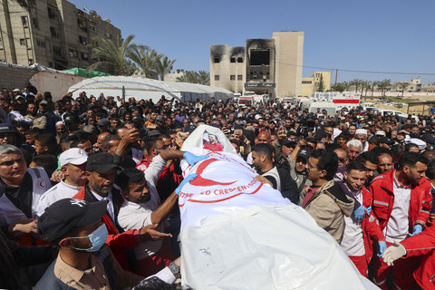 Anggota Bulan Sabit Merah Palestina dan layanan darurat lainnya membawa jenazah rekan-rekan penyelamat yang terbunuh seminggu sebelumnya oleh pasukan Israel di rumah sakit Nasser di Khan Yunis di Jalur Gaza selatan, Senin (31/3/2025). Foto: EYAD BABA/AFP