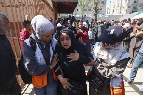 Kerabat berduka selama prosesi pemakaman anggota Bulan Sabit Merah Palestina dan layanan darurat lainnya yang terbunuh seminggu sebelumnya oleh pasukan Israel, di rumah sakit Nasser di Khan Yunis di Jalur Gaza selatan, Senin (31/3/2025). Foto: EYAD BABA/AFP