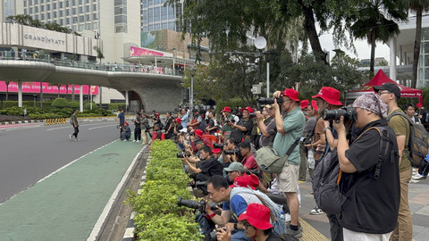 Suasana 200 fotografer dari Padepokan Bolos Gawe hunting foto bersama di Bundaran HI, Jakarta Pusat pada Selasa (1/4/2025).  Foto: Abid Raihan/kumparan