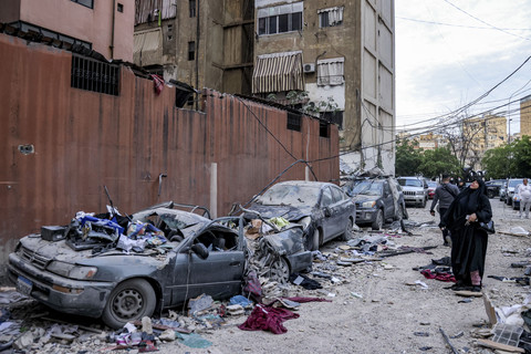 Seorang wanita melihat ke arah bangunan yang rusak di lokasi serangan Israel terhadap sebuah bangunan di pinggiran selatan Beirut, Lebanon, Selasa (1/4/2025). Foto: Ibrahim AMRO/AFP