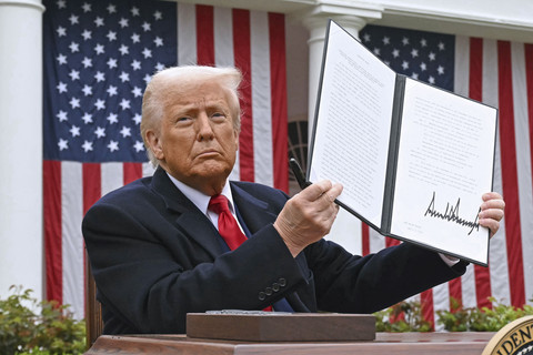 Presiden Donald Trump menunjukkan dokumen yang telah ditanda tangani mengenai tarif impor baru saat "Make America Wealthy Again" di Gedung Putih, Washington DC, Amerika Serikat, Rabu (2/4/2025). Foto: Brendan Smialowski/AFP