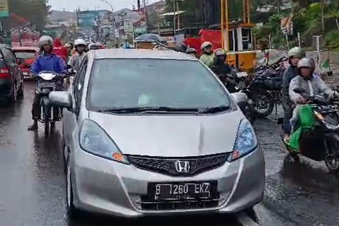 Anggota Satlantas Bogor membantu ibu hamil yang ingin melahirkan namun terjebak di one way Jalan Raya Puncak, Bogor pada Rabu (2/4/2025). Foto: Dok. Polres Bogor
