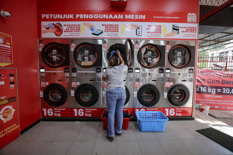 Pekerja menyelesaikan proses pencucian pakaian di salah satu kios di kawasan Kebon Kacang, Tanah Abang, Jakarta, Kamis (3/4/2025). Foto: Jamal Ramadhan/kumparan