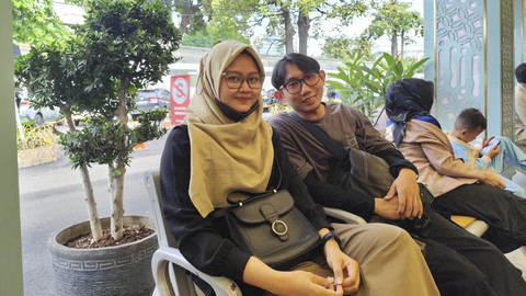 Sepasang suami istri Ika (kiri) dan Yudha (kanan), yang hendak berangkat mudik di Stasiun Pasar Senen ke Tegal, Jumat (4/4/2025). Foto: Alya Zahra/kumparan 