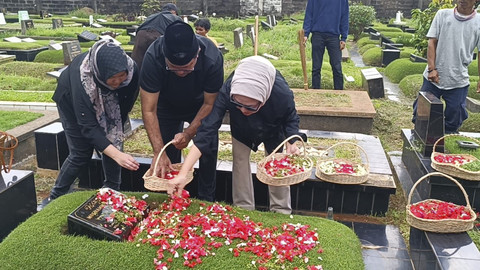Wagub Jakarta Rano Karno menabur bunga saat ziarah ke makam keluarga di TPU Tanah Kusir, Jakarta, Jumat (4/4/2025).  Foto: Thomas Bosco/kumparan