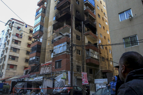 Orang-orang melihat sebuah apartemen yang hancur akibat serangan Israel di Sidon, Lebanon, Jumat (4/4/2025). Foto: Mahmoud Zayyat/AFP