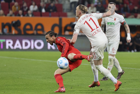 Pemain Bayern Muenchen Leroy Sane berebut bola dengan pemain Augsburg Marius Wolf pada pertandingan Bundesliga Jerman di Augsburg, Southern, Jerman, Jumat (4/4/2025). Foto: Alexandra BEIER/AFP