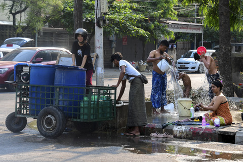 Sejumlah warga mandi setelah mendapatkan air bersih di Mandalay, Myanmar, Jumat (4/4/2025). Foto: Stringer/Reuters