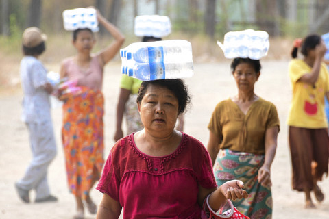 Sejumlah warga membawa botol untuk mencari air bersih yang di Mandalay, Myanmar, Jumat (4/4/2025). Foto: Stringer/Reuters