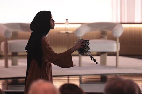 Seorang demonstran pro-Palestina, Ibtihal Aboussad, memegang kufiyyeh saat mereka menginterupsi CEO Microsoft AI, Mustafa Suleyman di markas besar Microsoft, Jumat (4/4/2025). Foto: Jason Redmond/REUTERS 