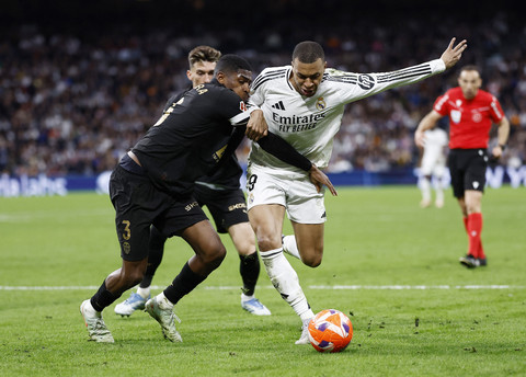 Pemain Real Madrid, Kylian Mbappe, beraksi dengan pemain Valencia, Cristhian Mosquera pada pertandingan Liga Spanyol antara Real Madrid vs Valencia di ...                    </div>

                    <div class=